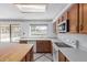 This bright kitchen features a tile floor, light wood cabinets and a view to the backyard at 987 E Divot Dr, Tempe, AZ 85283