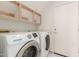This laundry room includes wooden storage shelves, a white door, and a Samsung washer and dryer at 987 E Divot Dr, Tempe, AZ 85283