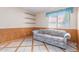 Bright living room features a cozy sofa, wood-paneled walls, and a window with a light blue valance at 987 E Divot Dr, Tempe, AZ 85283