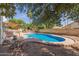 Beautiful backyard pool with an outdoor kitchen and mature trees for shade at 987 E Divot Dr, Tempe, AZ 85283