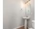 Powder room featuring a pedestal sink, toilet, and modern lighting at 10009 W Bloch Rd, Tolleson, AZ 85353