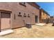 Exterior view of backyard with stucco wall, windows, and concrete patio area at 10331 W Devonshire Ave, Phoenix, AZ 85037