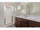 This bathroom features a glass shower and dark-wood vanity with white sink at 10331 W Devonshire Ave, Phoenix, AZ 85037