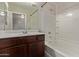 Bathroom features a combination bathtub and shower with white tile surround and a dark wood vanity at 10331 W Devonshire Ave, Phoenix, AZ 85037