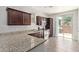 Stylish kitchen with granite countertops, dark cabinets, and stainless steel appliances, designed for culinary excellence at 10331 W Devonshire Ave, Phoenix, AZ 85037