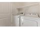 Bright laundry room featuring a Samsung washer, Whirlpool dryer, and a shelf for storage at 10331 W Devonshire Ave, Phoenix, AZ 85037