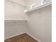 Bright walk-in closet with white shelving and neutral carpeting offering ample storage space at 10331 W Devonshire Ave, Phoenix, AZ 85037