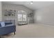 Bonus room featuring a light-colored carpet, a blue couch, and shelves for storage at 1244 W Straford Ave, Gilbert, AZ 85233