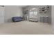 Bonus room featuring a light-colored carpet, a blue couch, and shelves for storage at 1244 W Straford Ave, Gilbert, AZ 85233