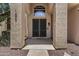 Close up of a home's entryway featuring double doors, textured columns, and manicured landscaping at 1244 W Straford Ave, Gilbert, AZ 85233