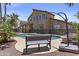Backyard pool with a seating bench, surrounded by lush greenery and a secure fence at 1244 W Straford Ave, Gilbert, AZ 85233