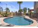 Backyard pool featuring stone accents, desert landscaping, and privacy fence at 1244 W Straford Ave, Gilbert, AZ 85233