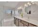 Luxurious bathroom featuring dual sinks, granite countertop, modern fixtures, soaking tub, and stylish vanity lights at 1264 S Sierra St, Gilbert, AZ 85296
