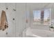 Modern bathroom with a glass-enclosed shower, soaking tub, and marble-look tile, creating a spa-like ambiance at 1264 S Sierra St, Gilbert, AZ 85296