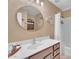 Well-lit bathroom with a modern vanity, round mirror, and shower with white curtain at 1264 S Sierra St, Gilbert, AZ 85296