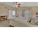 Tranquil main bedroom features a ceiling fan, barn door to bath, and bright windows, enhancing the room's appeal at 1264 S Sierra St, Gilbert, AZ 85296