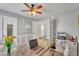 Well-lit office space boasts a glass desk, floral wallpaper accents, and a door, blending functionality and style at 1264 S Sierra St, Gilbert, AZ 85296