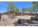 Desert landscaped backyard with covered patio and block fence at 1563 E Peregrine Trl, Casa Grande, AZ 85122