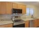 Modern kitchen features stainless steel appliances, granite countertops, and a built-in microwave at 1563 E Peregrine Trl, Casa Grande, AZ 85122