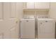 Clean laundry room equipped with a washer, dryer, and storage cabinets at 1563 E Peregrine Trl, Casa Grande, AZ 85122