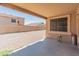 Comfortable covered back patio looks out to a low-maintenance yard and block wall fencing at 15985 W Bartlett Ave, Goodyear, AZ 85338
