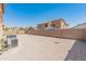 Backyard featuring minimal landscaping, block wall fencing, and mature trees at 15985 W Bartlett Ave, Goodyear, AZ 85338