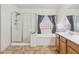 Bright bathroom features a shower, soaking tub and vanity with tile floors at 15985 W Bartlett Ave, Goodyear, AZ 85338