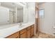 Bathroom features a vanity and shower behind large mirror at 15985 W Bartlett Ave, Goodyear, AZ 85338