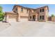 Beige two-story home featuring a spacious driveway and attached three-car garage at 15985 W Bartlett Ave, Goodyear, AZ 85338