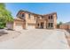 Beige two-story home featuring a spacious driveway and attached three-car garage at 15985 W Bartlett Ave, Goodyear, AZ 85338