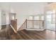 Hallway with wood floors, decorative railing and views into other rooms at 15985 W Bartlett Ave, Goodyear, AZ 85338