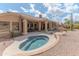 Inviting backyard featuring a spa, covered patio with seating, and desert landscaping at 16436 S 1St Ave, Phoenix, AZ 85045