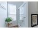 Well-lit bathroom with glass-enclosed shower, blinds, and decorative green plant at 16436 S 1St Ave, Phoenix, AZ 85045