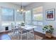 Dining area with wood floors, white table and chairs, and large windows with light control shades at 16436 S 1St Ave, Phoenix, AZ 85045