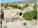Aerial view of a home with a two-car garage, desert landscaping, and a beige tile roof nestled in a neighborhood at 16436 S 1St Ave, Phoenix, AZ 85045