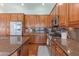 A kitchen with wood cabinets, granite counters, stainless appliances, and hardwood flooring at 16436 S 1St Ave, Phoenix, AZ 85045