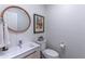 Stylish powder room with round mirror and modern fixtures, great for guests at 16436 S 1St Ave, Phoenix, AZ 85045