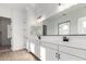 Modern bathroom featuring dual sinks, white cabinetry, and a large mirror at 16455 W Avenida Del Sol --, Surprise, AZ 85387