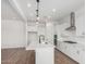 Open-concept kitchen featuring a large island, modern appliances, white cabinets, and wood-look tile flooring at 16455 W Avenida Del Sol --, Surprise, AZ 85387