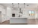 Bright kitchen featuring white cabinets, stainless steel appliances, a spacious island, and modern pendant lighting at 16455 W Avenida Del Sol --, Surprise, AZ 85387