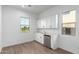 Bright room featuring a kitchenette with white cabinets, stainless steel beverage fridge, and stylish flooring at 16455 W Avenida Del Sol --, Surprise, AZ 85387