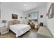 Bright bedroom with wood-look tile flooring, white walls, and a view of the front yard at 17003 W Alameda Rd, Surprise, AZ 85387