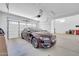 Clean garage features an overhead door and a stylish car parked inside at 17003 W Alameda Rd, Surprise, AZ 85387