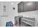 Laundry room features front-load washer and dryer, storage cabinets, plus a tile floor at 17003 W Alameda Rd, Surprise, AZ 85387