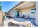 Covered patio with grey pavers, chairs and table and uniquely sculpted driftwood accent at 17003 W Alameda Rd, Surprise, AZ 85387