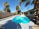 Backyard with an inviting pool surrounded by a gray concrete deck and lush palm trees on a sunny day at 1712 E Manhatton Dr, Tempe, AZ 85282