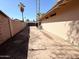 Side yard with a dirt lot, block wall, and a view of palm trees at 1712 E Manhatton Dr, Tempe, AZ 85282