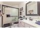 Bathroom featuring glass enclosed shower, white vanity and black framed mirror at 17543 N Rainbow Cir, Surprise, AZ 85374