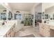 Bright bathroom with tiled floor, double sinks, large mirror, stall shower and separate tub at 17543 N Rainbow Cir, Surprise, AZ 85374
