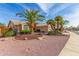 Desert landscaping and mature palm trees accent this beautiful tan single-story home at 17543 N Rainbow Cir, Surprise, AZ 85374